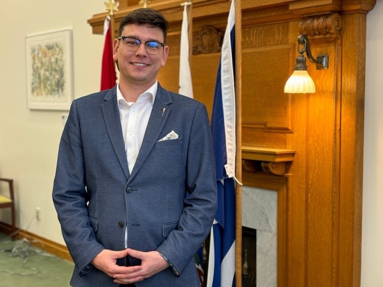 Portrait of Jordan McPhail with flags in background