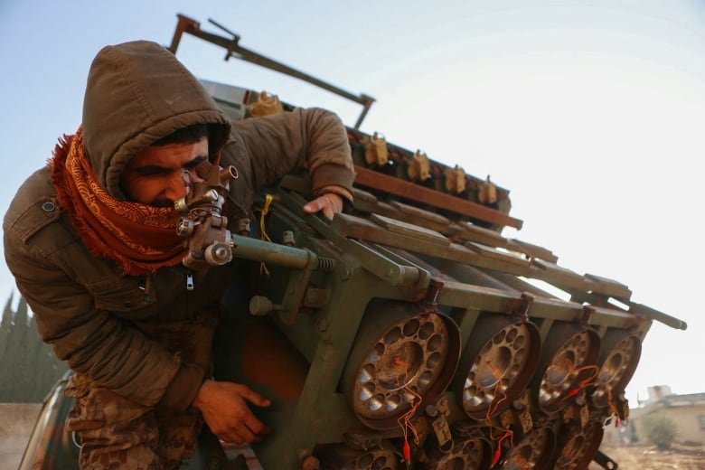 A fighter inspects a seized Syrian army rocket launcher in northern Syria.