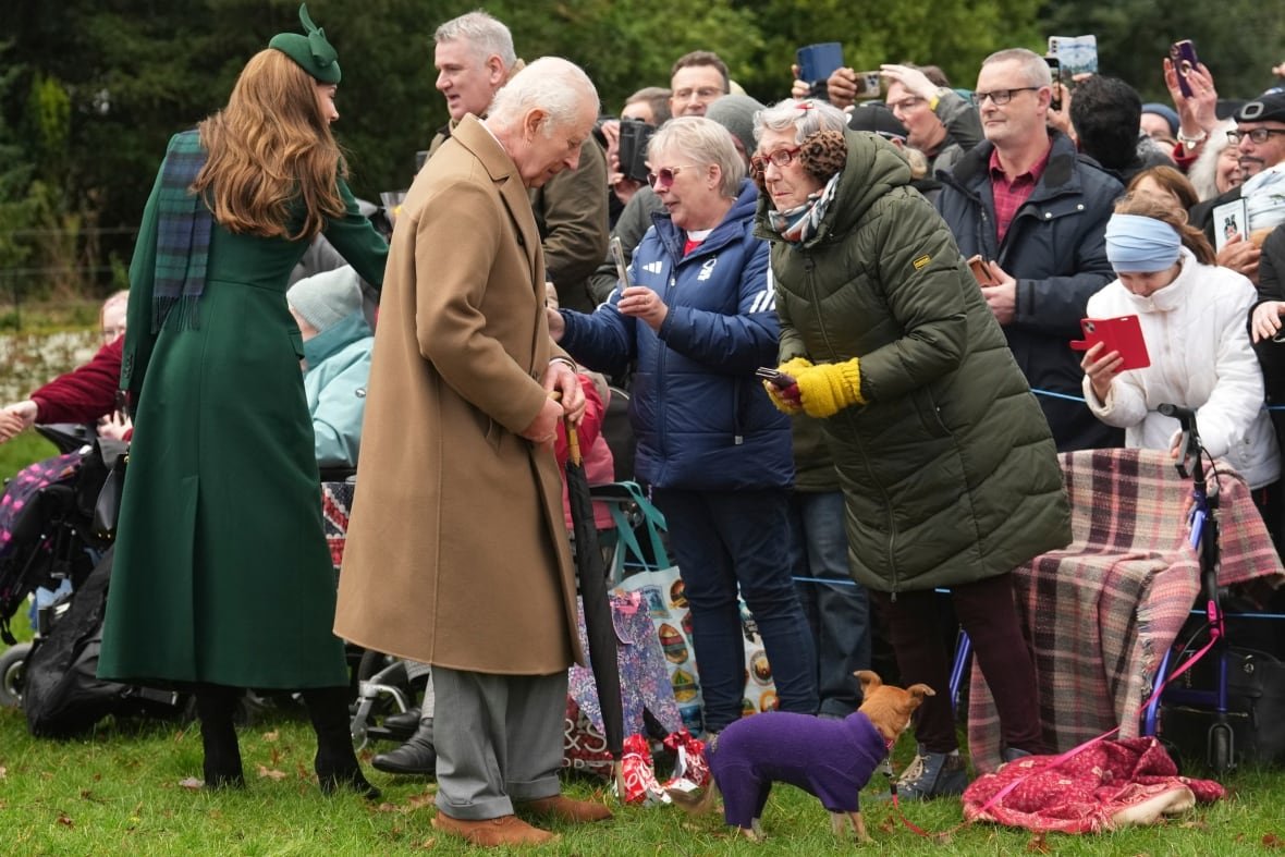britain-royals-christmas-2 A man speaks to a bystander in a crowd.