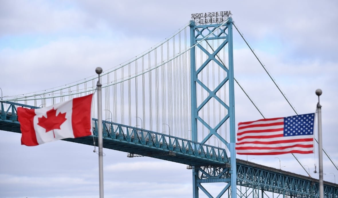 covid-cda-us-students-20200727 Canadian and American flags fly near the Windsor-Detroit Ambassador Bridge