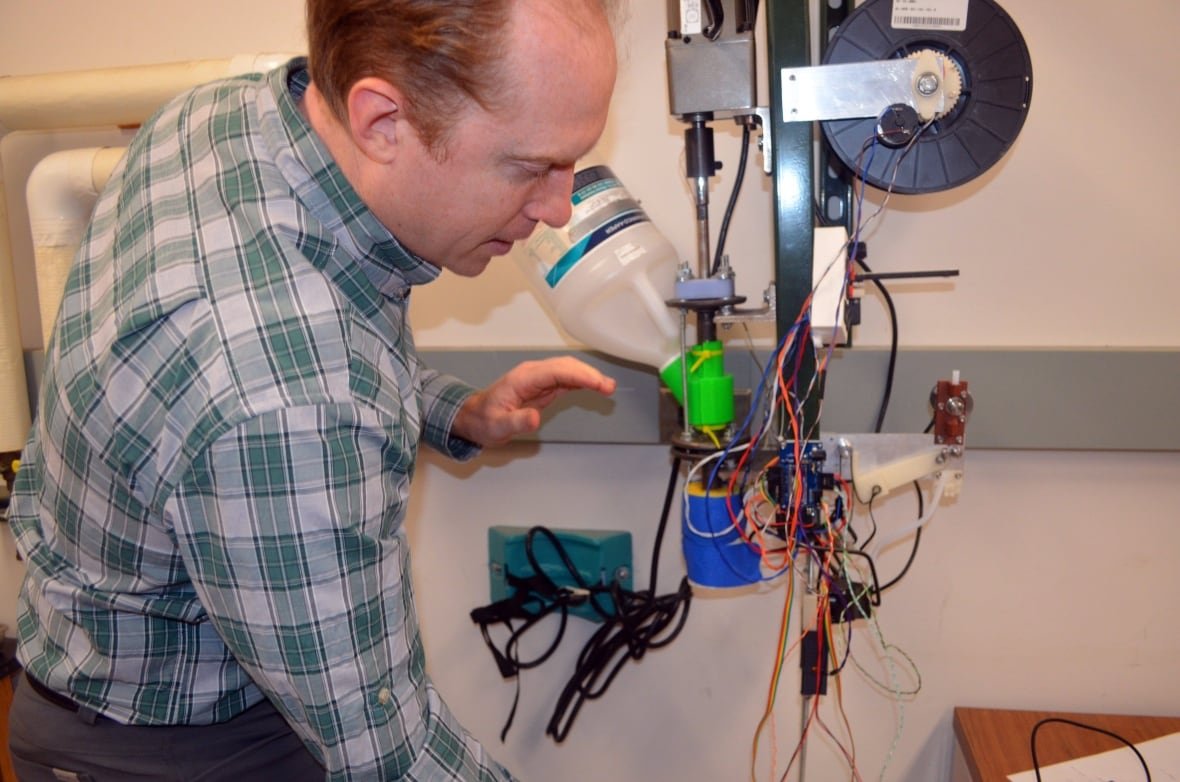 exchange-recyclebot A man in a checkered shirt is pictured demonstrating how to use technological equipment.