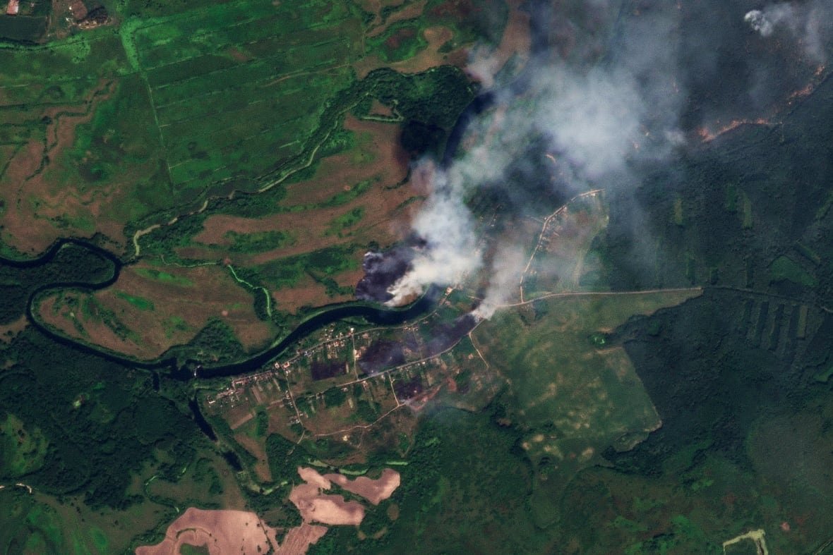 russia-ukraine-war-1 This satellite image shows large plumes of smoke rising from a village.