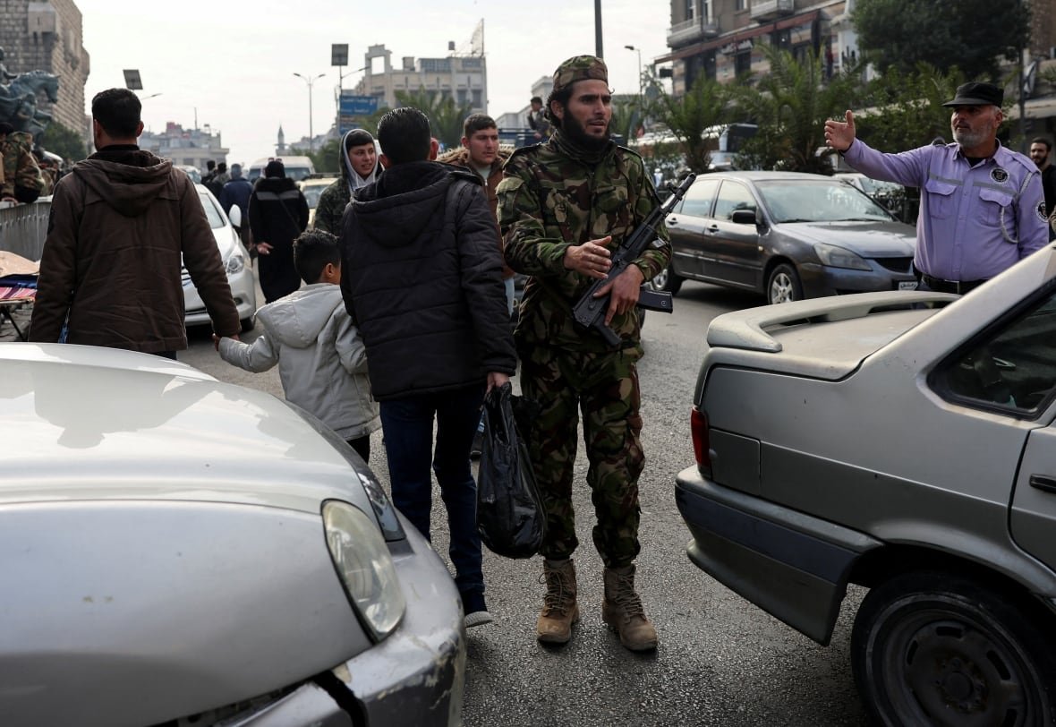 syria-security-4 A fighter of the ruling Syrian body is seen carrying a rifle.