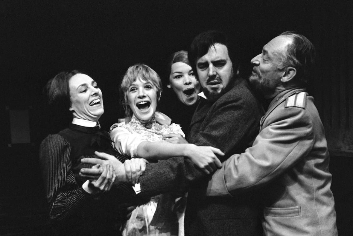 britain-obit-glenda-jackson A group of people are all embracing and clustered together, in various stages of emotion, some excited, others looking confused.