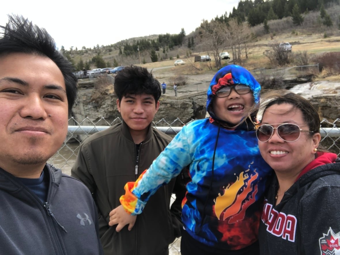 A family of four take a selfie near a waterfall in Alberta, Canada.