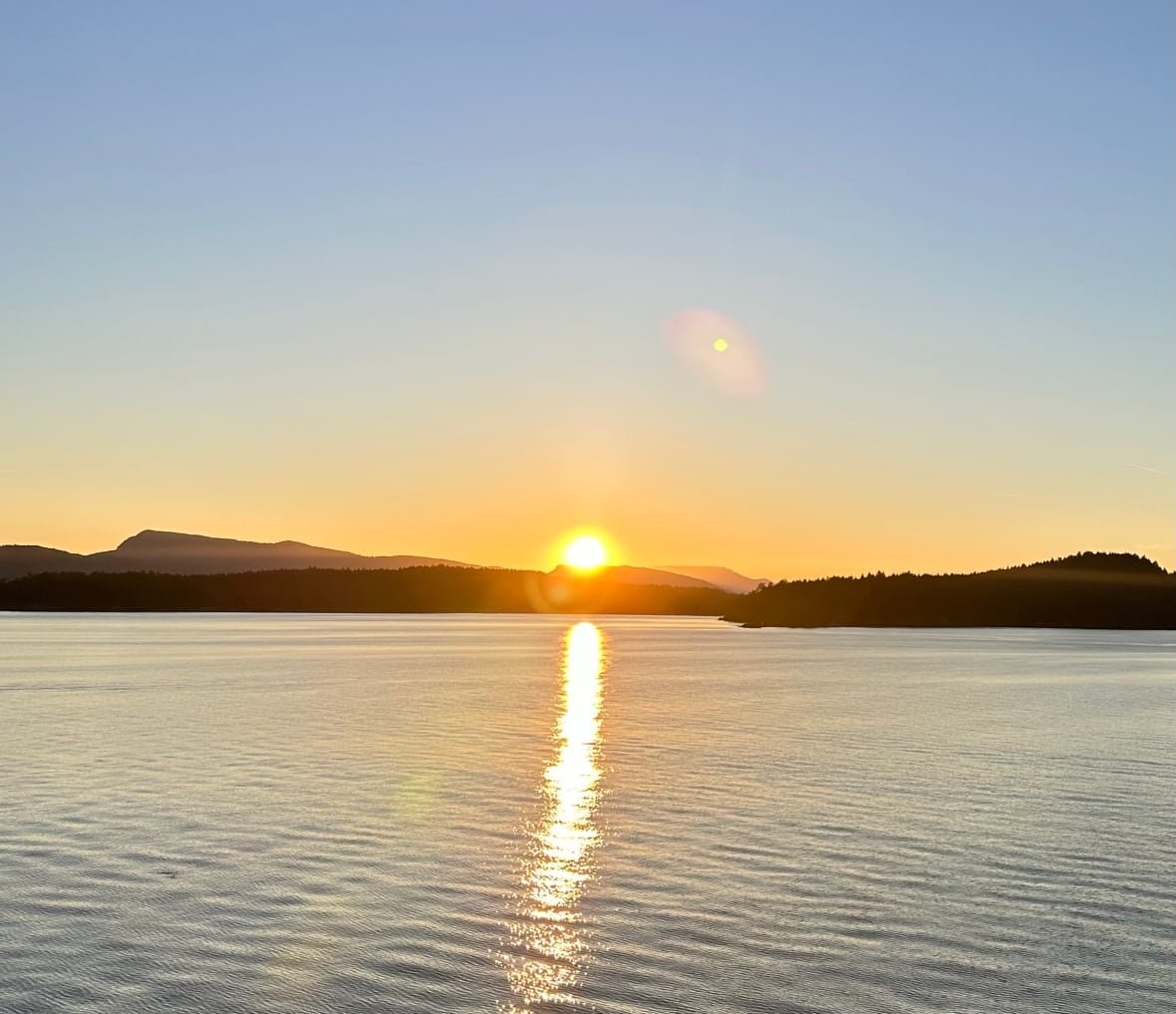 A sun setting over a lake.