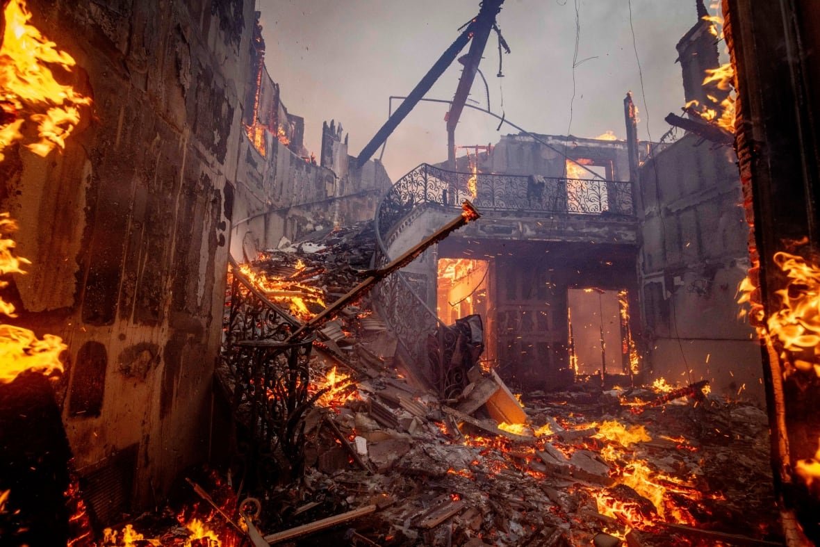 california-wildfires-3 A large homes burns revealing a charred winding staircase.