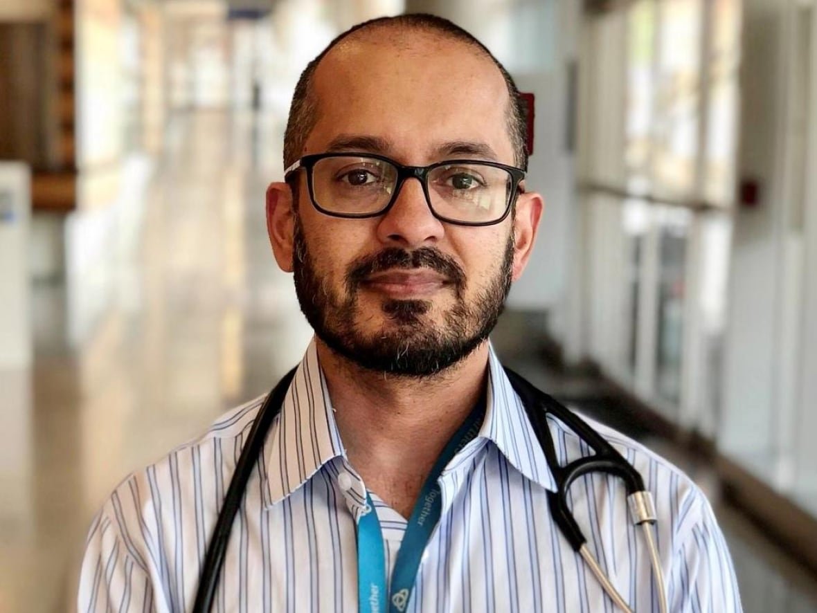 dr-sumon-chakrabarti-1 A doctor looks into the camera. He wears a stethoscope around his neck.