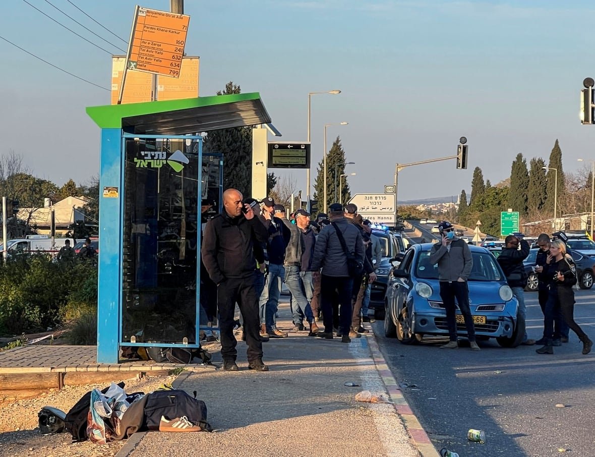 israel-palestinian-violence People gathered at a crime scene near a bus stop.