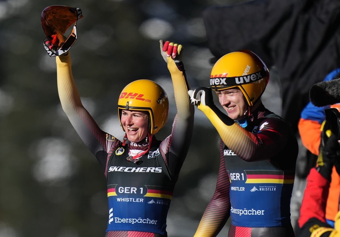 julia-taubitz-and-max-langenhan-1 A male and a female luge athlete celebrates after winning a mixed event.