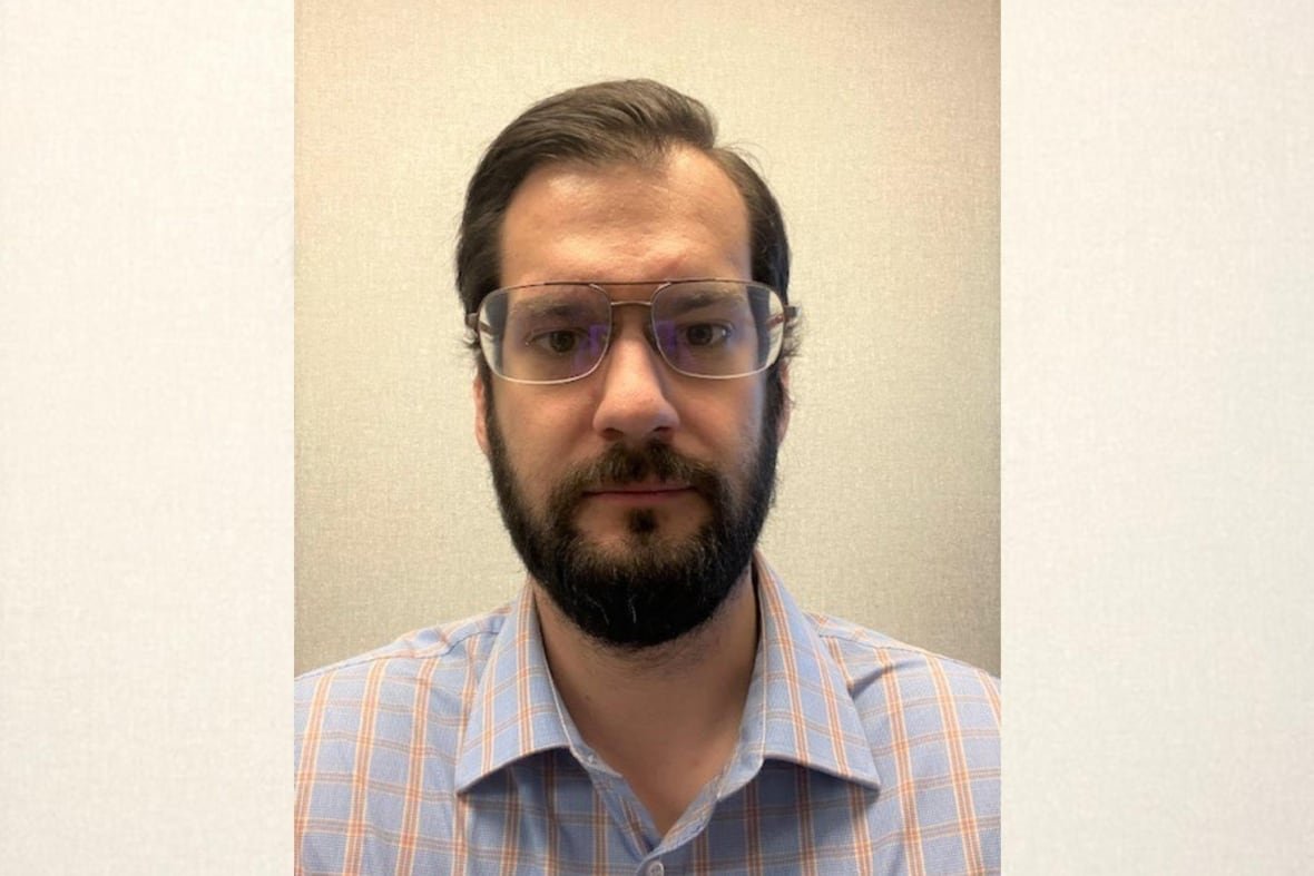 tom-power-1 A man wearing glasses and a blue and orange checked shirt