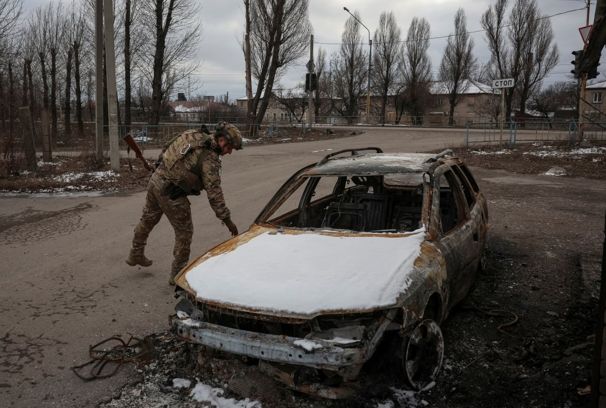 ukrainian-police-officer-examines-a-destroyed-car-in-pokrovsk-ukraine A Ukrainian police office inspects a car in Pokrovsk, Ukraine, which was damaged by Russian military strikes.