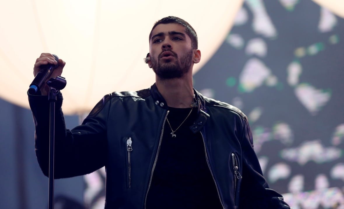 usa-entertainment A man in a black leather jacket is seen onstage from the waist up, holding a microphone stand.