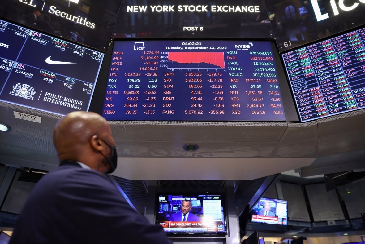 usa-stocks-1 Man looks up at stock market screen