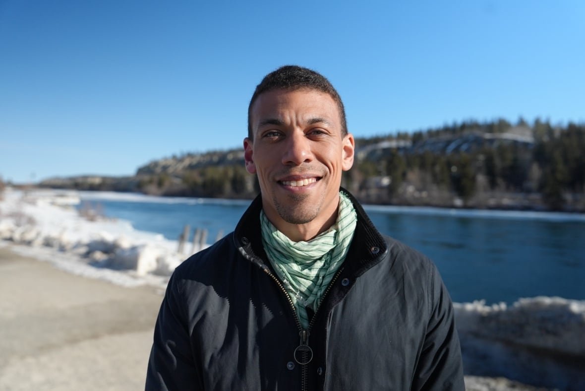 jonathan-pedneault-1 A man stands near a river in winter.
