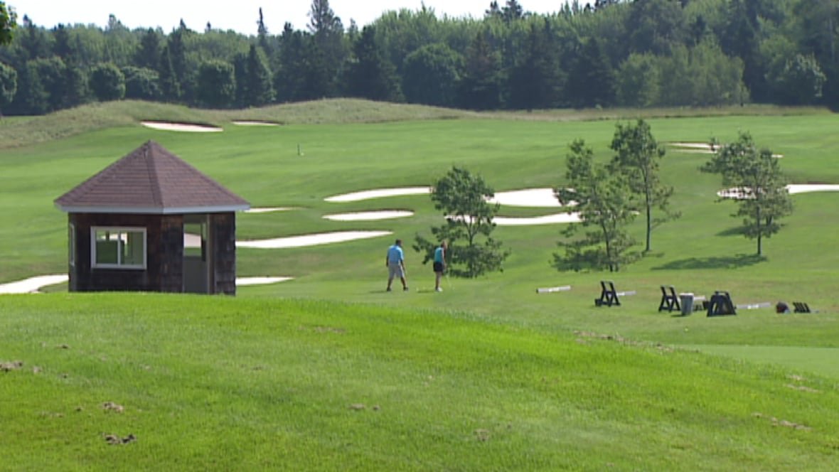 mill-river Two golfers walk on the grass at the Mill River golf course.