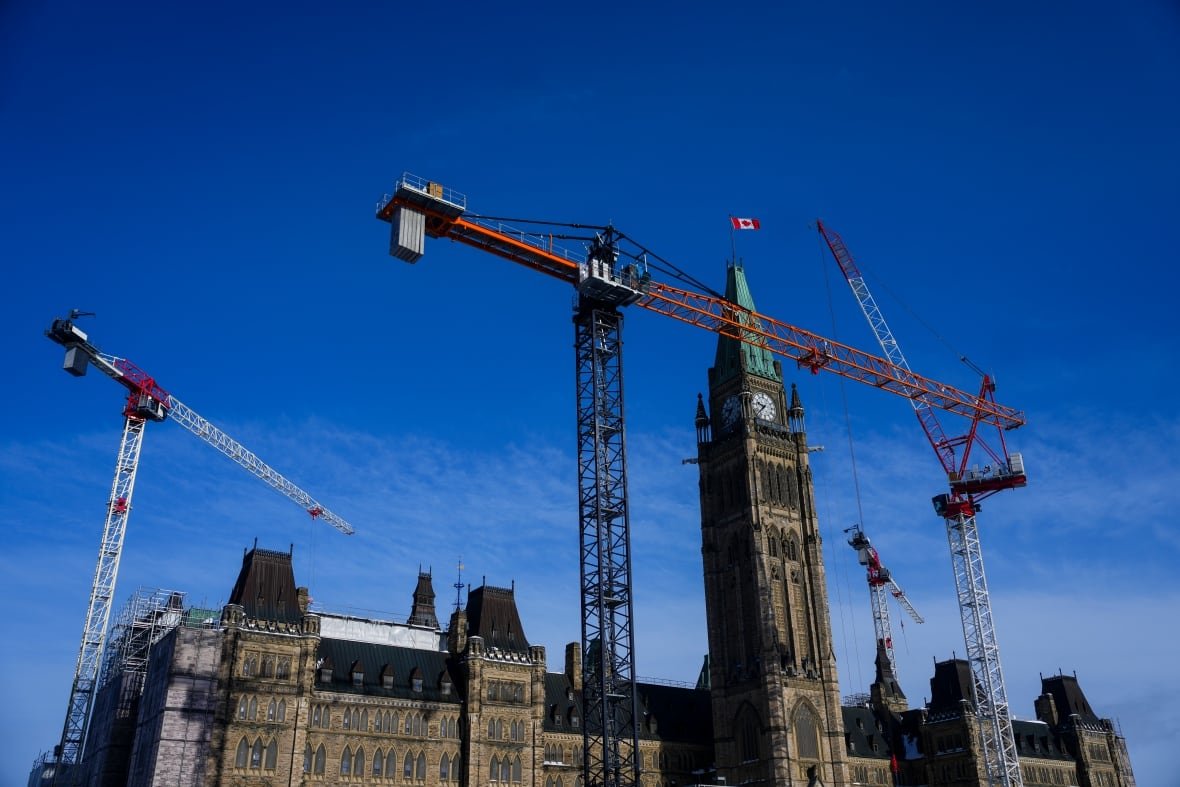 parliament-hill-feature-20250218-1 A series of cranes are seen over Centre Block on Parliament Hill in Ottawa.