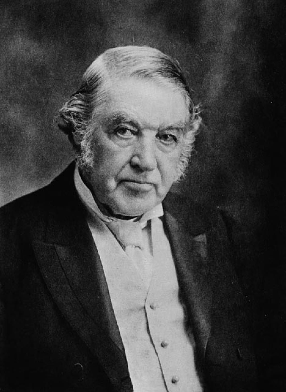 sir-charles-tupper-1896-1 An old black and white photograph shows a man with thick sideburns in a suit.