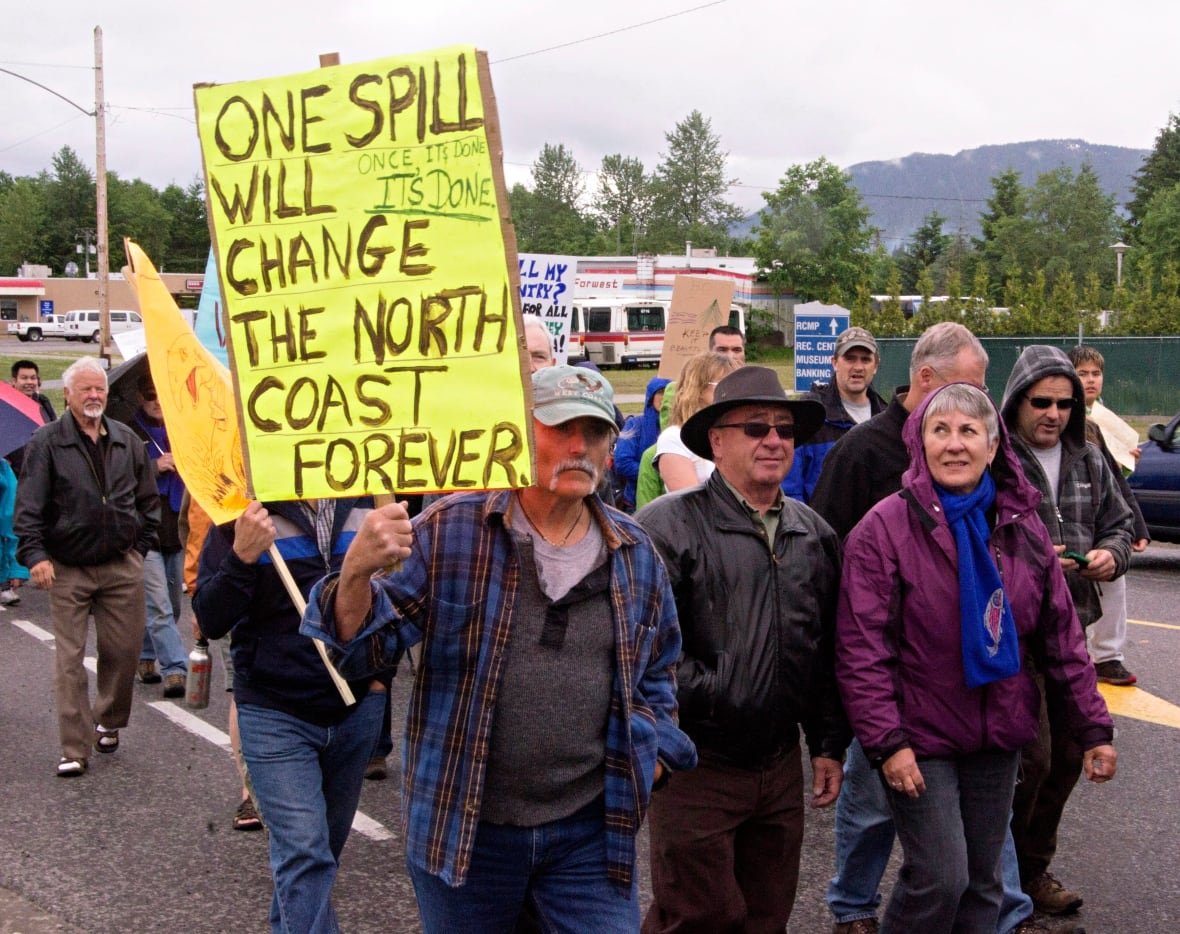 anti-enbridge-rally-kitimat-june-2012-3 People march holding anti-oil signs.