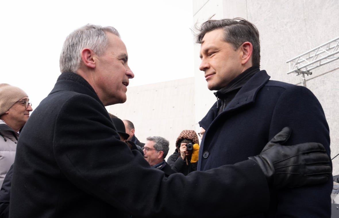 carney-and-poilievre-1 Two men in suits and overcoats shake hands on a cold day.