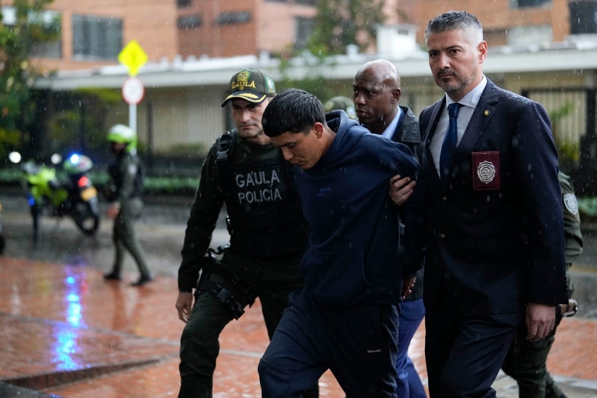 colombia-chile-tren-de-aragua-1 Police escort a handcuffed suspect.
