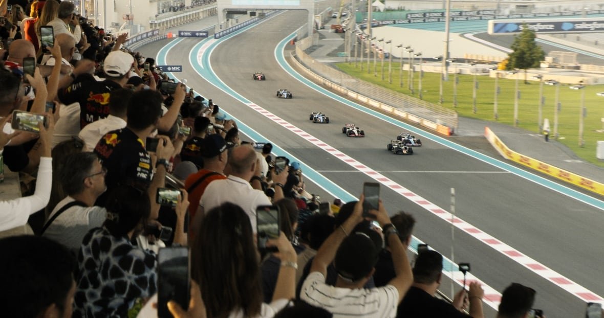 f1-the-movie-5 A racing car track with a stand full of fans is shown.