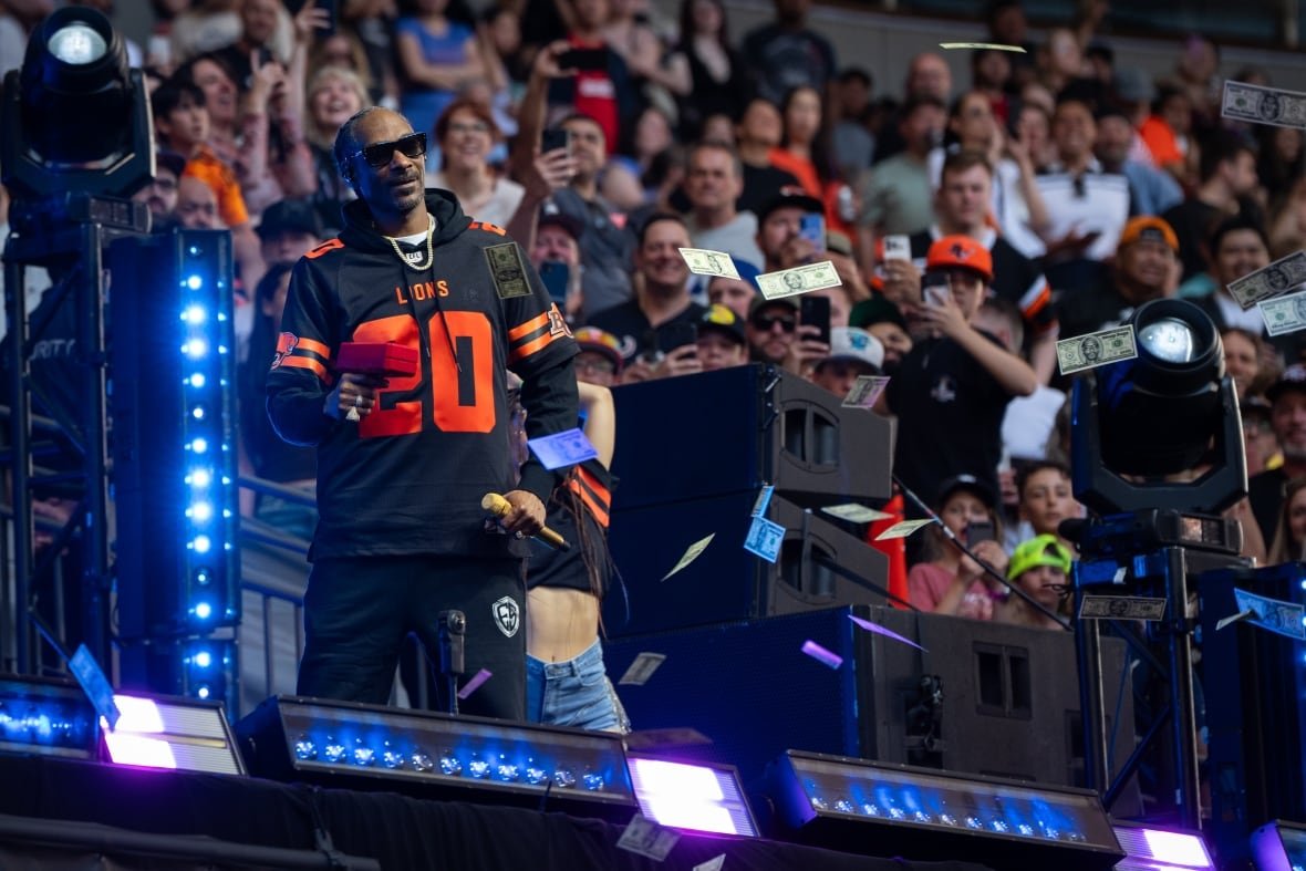 fbo-cfl-elks-lions-20250607-2 Snoop Dogg shoots fake money as he performs.