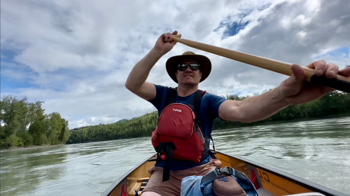 taylor-bachrach-1 A close up picture of a man in a canoe wearing a full brimmed hat, sunglasses and holding a paddle. The canoe is in the Skeena River in B.C.