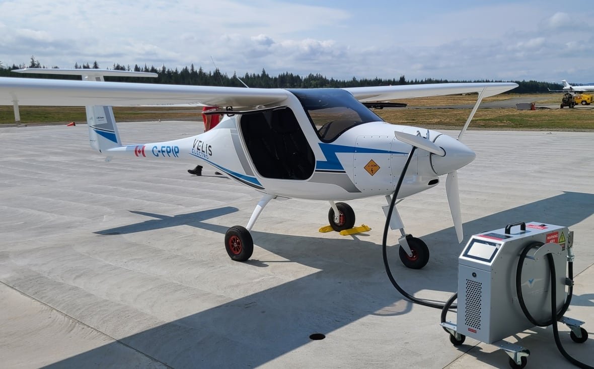 An e-plane sitting at an airfield, charging.