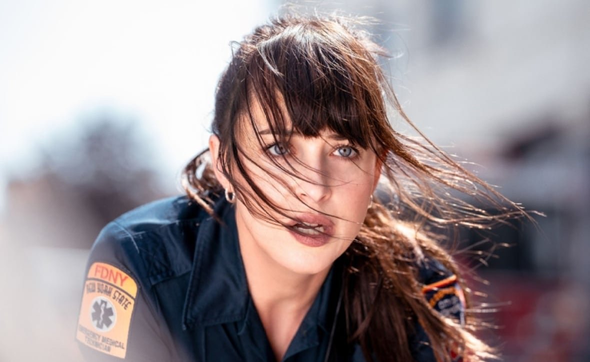 A closeup of a woman in a paramedic's uniform, looking off screen.