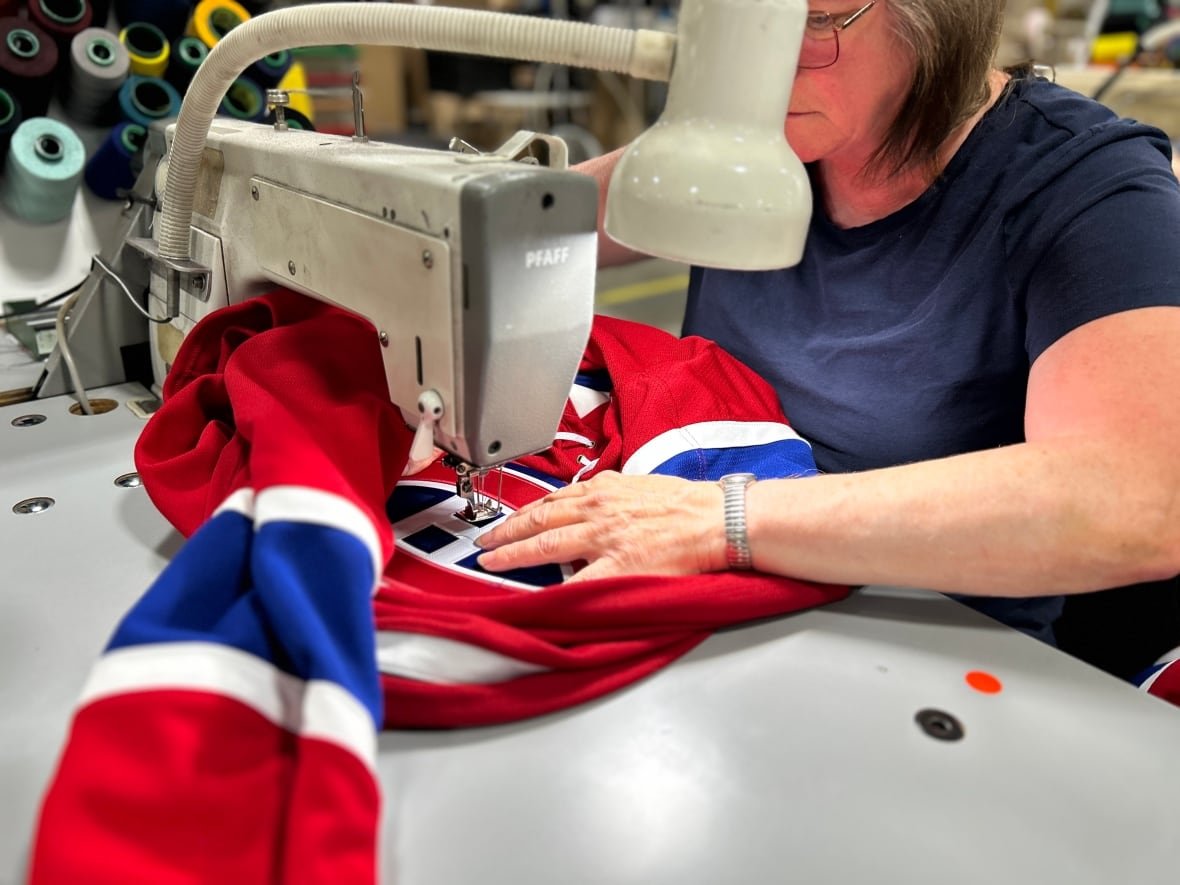 Woman sews hockey jersey with Canadiens logo