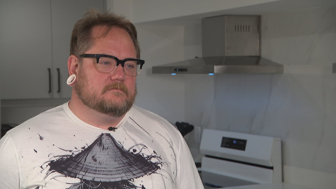 A man stands in his kitchen.