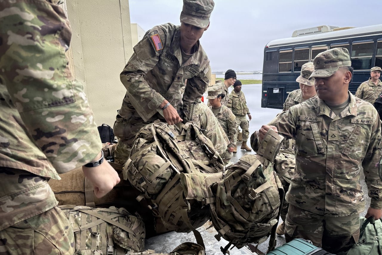 Soldiers unloading supplies from a vehicle.