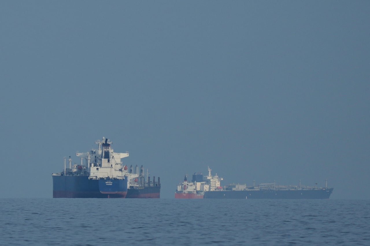 Tanker ships are seen on the water.