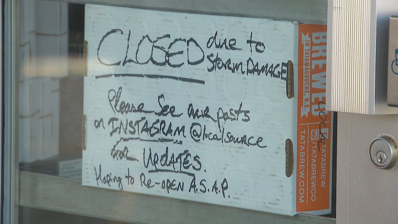 A sign taped to a window reads: "Closed due to storm damage. Please see our posts on Instagram @localsource for updates. Hoping to re-open A.S.A.P."