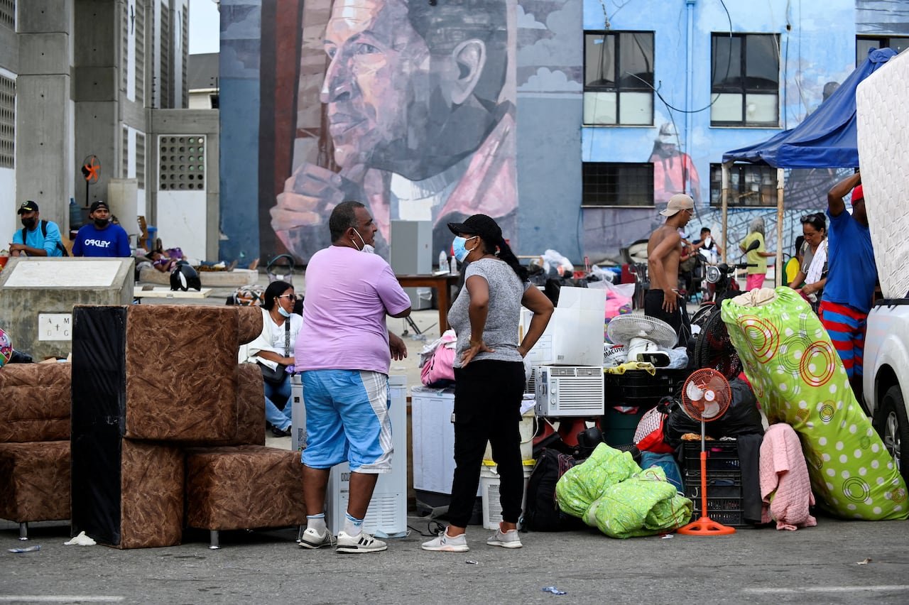 default-153 People stand with their belongings outside.