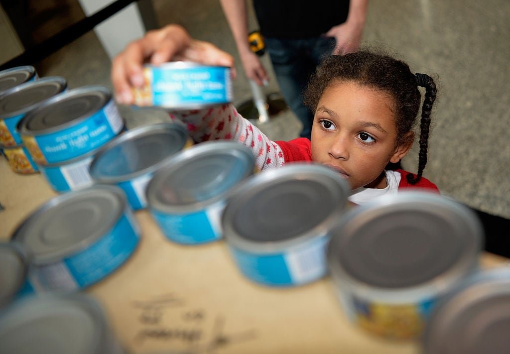 default-99 Girl picks up a can of tuna from a shelf